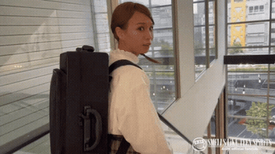 Woman Carrying Suitcase With Smells Like Teen Spirit Logo GIF