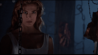Woman Chained To Wall Looking At Camera GIF
