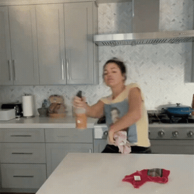 Woman Cleaning Kitchen Counter Wearing Woman-Shirt GIF