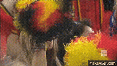 Woman Covered In Yellow And Red Feathers On Ground GIF