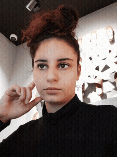 Woman Covering Ear In Black Turtleneck GIF