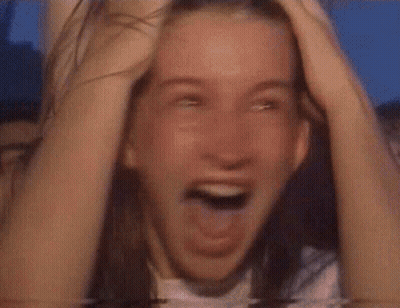 Woman Covering Face In Front Of Crowd GIF