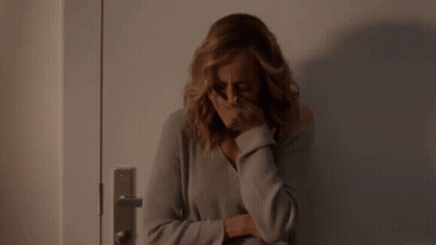 Woman Covering Face In Front Of Door GIF