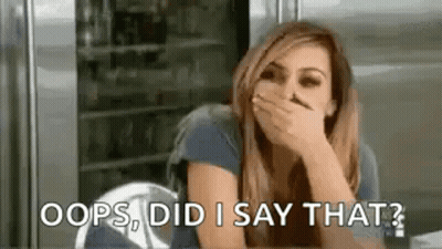 Woman Covering Mouth At Table In Front Of Refrigerator GIF