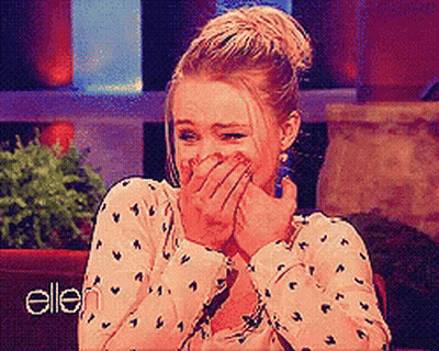 Woman Covering Mouth In Front Of Ellen Sign GIF