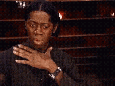 Woman Covering Mouth In Front Of Wooden Wall GIF