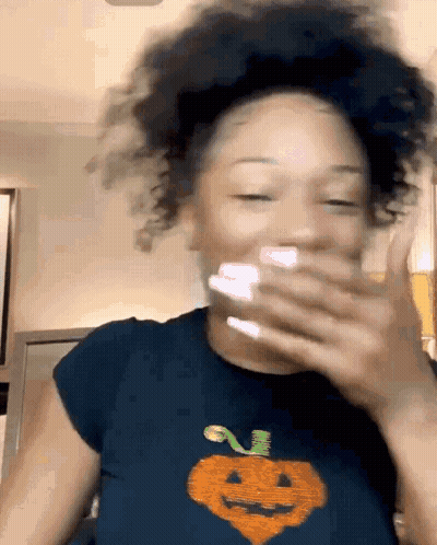 Woman Covering Mouth Wearing Pumpkin Shirt GIF