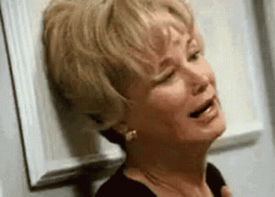 Woman Crying Leaning Against Wall With Eyes Closed GIF