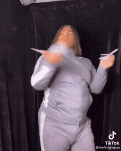 Woman Dancing Holding Paper In Front Of Black Curtain GIF