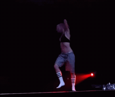 Woman Dancing In Black Bra And Grey Shorts On Stage GIF
