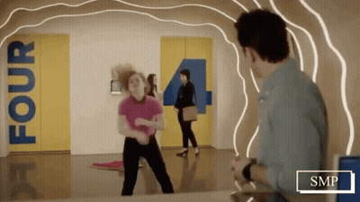 Woman Dancing In Hallway With Sign Saying Four GIF