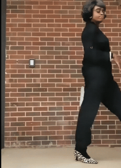Woman Dancing In Leopard Shoes Near Brick Wall GIF