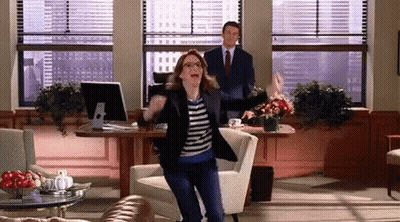 Woman Dancing In Living Room In Front Of Man In Suit GIF