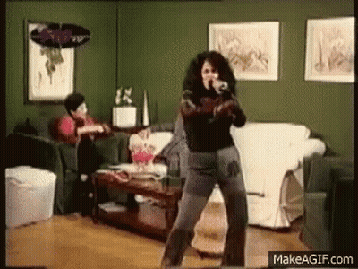Woman Dancing In Living Room Man Sitting On Couch GIF