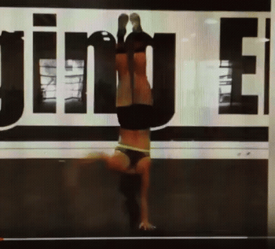 Woman Doing Handstand In Front Of Jinue Sign GIF