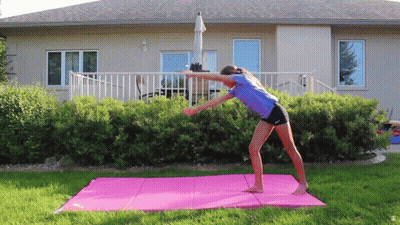 Woman Doing Yoga On Pink Mat In Front Of House GIF
