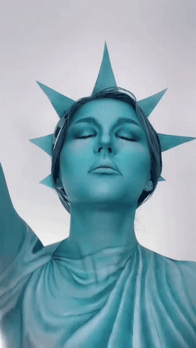 Woman Dressed As Statue Of Liberty Eyes Closed GIF