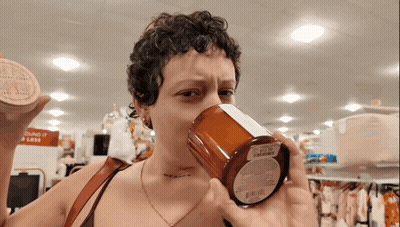 Woman Drinking From Candle In Front Of Sound It Is Less Sign GIF