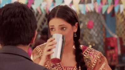 Woman Drinking From Metal Cup Looking At Man GIF