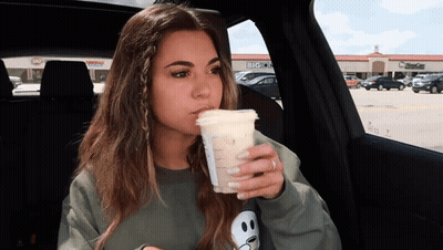 Woman Drinking From Plastic Cup In Car With Big O's GIF