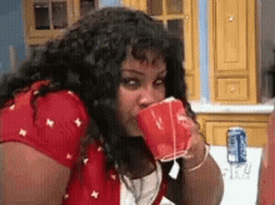 Woman Drinking From Red Cup In Kitchen GIF