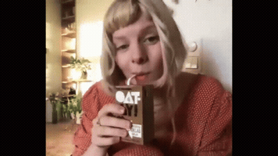 Woman Drinking Oat Milk Through Straw GIF