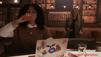 Woman Drinking Orange Juice Next To Laptop GIF