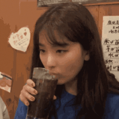 Woman Drinking Soda By Wall With Chinese Writing GIF