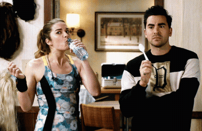 Woman Drinking Water Next To Man With Spoon GIF