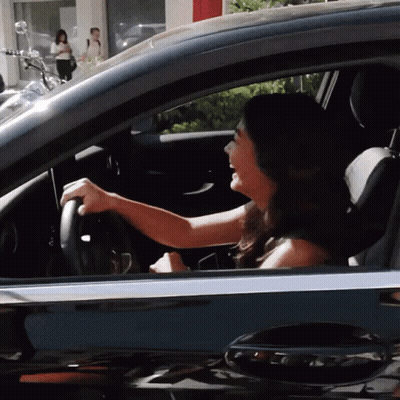 Woman Driving Car With Motorcycle Parked Behind GIF
