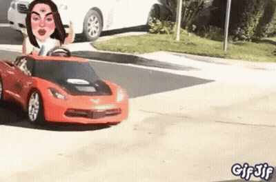 Woman Driving Toy Car Down Street GIF