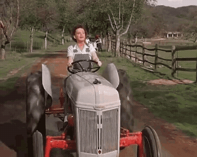 Woman Driving Tractor On Dirt Road GIF