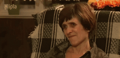 Woman Eating Apple From Man's Hand On Couch GIF