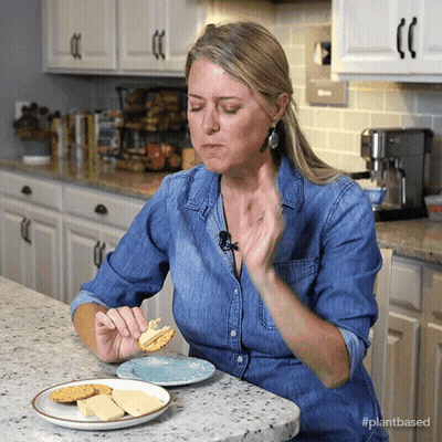 Woman Eating Cheese And Crackers With Plantbased Shirt GIF