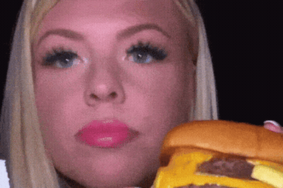 Woman Eating Cheeseburger With Eyes Closed GIF