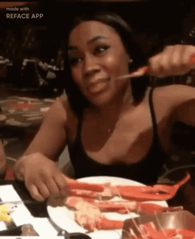 Woman Eating Crab Legs At Table GIF