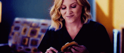 Woman Eating Hamburger In Living Room GIF