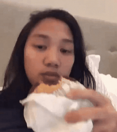 Woman Eating Hamburger On Bed GIF