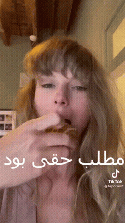 Woman Eating Hamburger With Arabic Writing