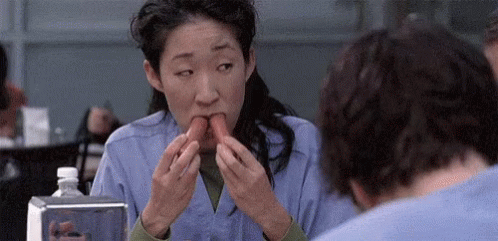 Woman Eating Hot Dog Next To Man In Restaurant GIF