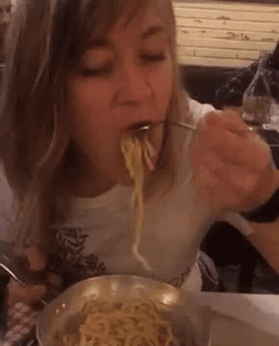 Woman Eating Noodles From Bowl With Fork GIF