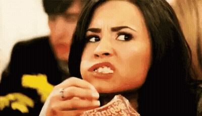 Woman Eating Popcorn Making Funny Face While Man Looks On GIF