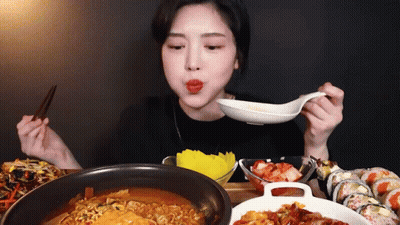 Woman Eating Ramen And Sushi With Chopsticks And Spoon GIF
