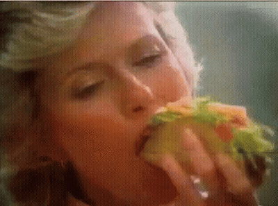 Woman Eating Sandwich With Eyes Closed GIF