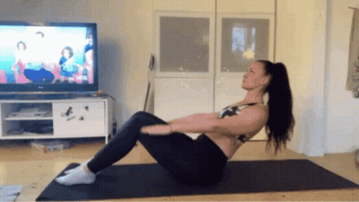 Woman Exercising On Yoga Mat In Front Of TV GIF