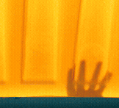 Woman Face Behind Yellow Curtain GIF