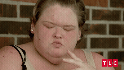 Woman Face With TLC Letters On Brick Wall GIF