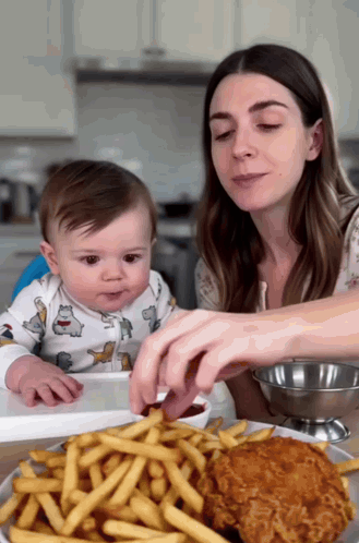 Woman Feeding Baby French Fries and Chicken