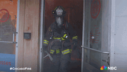 Woman Fire Fighter Getting Out Smokey Building GIF