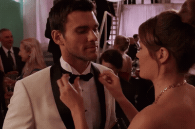 Woman Fixing Man's Bow Tie At Party GIF